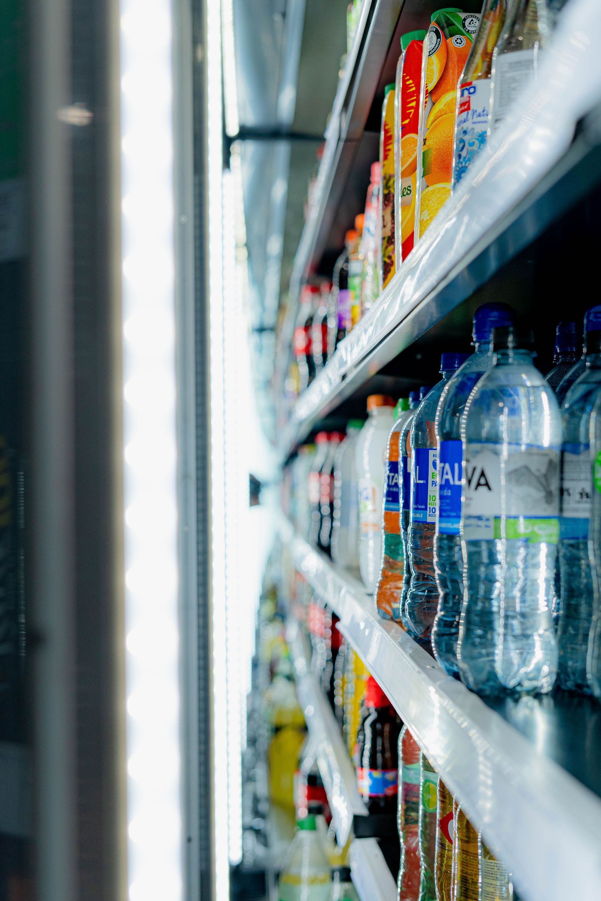 Supermarket aisle with shelves of drinks and bottled water in focus