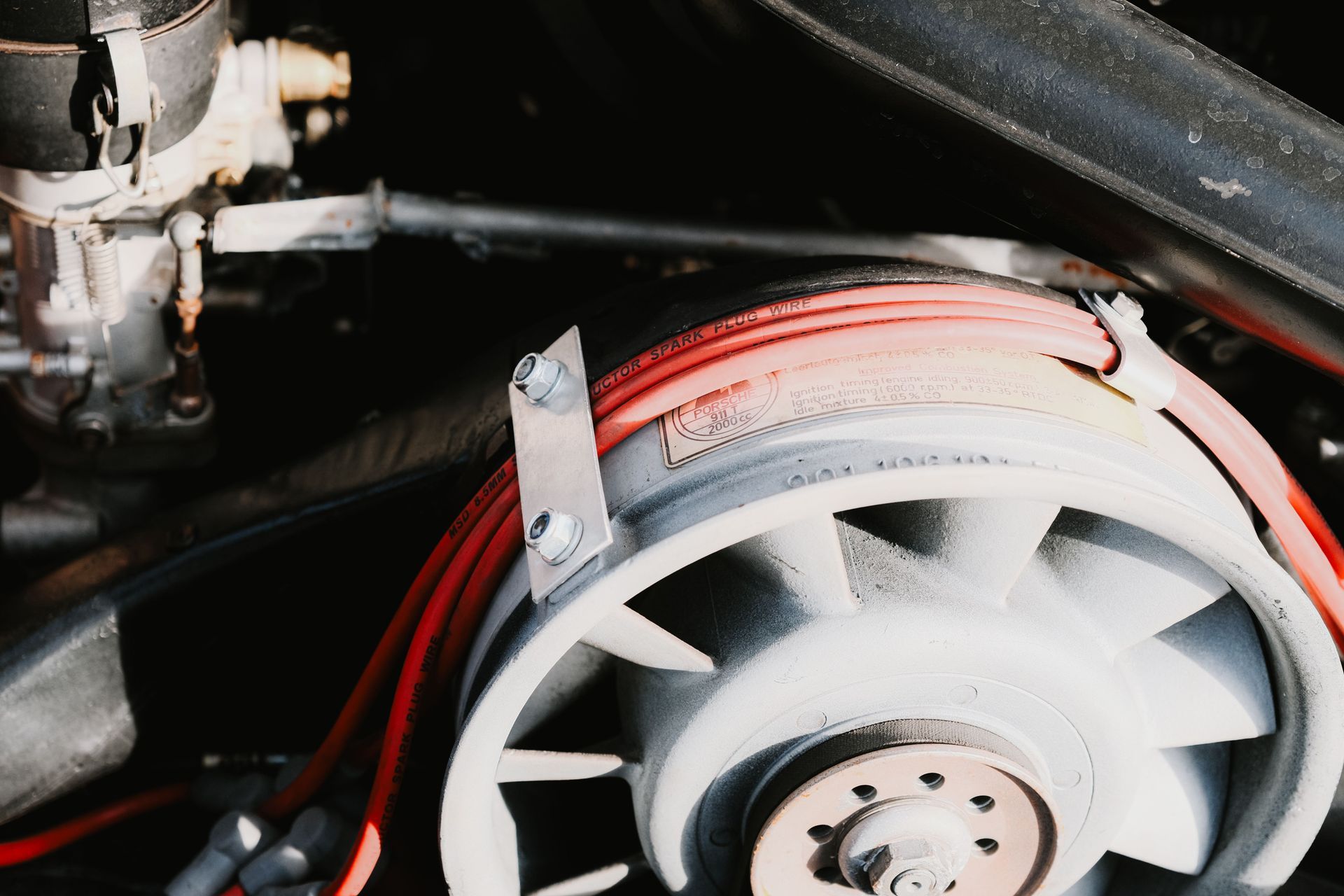 Close-up of a white fan with red wiring inside a machine or engine compartment