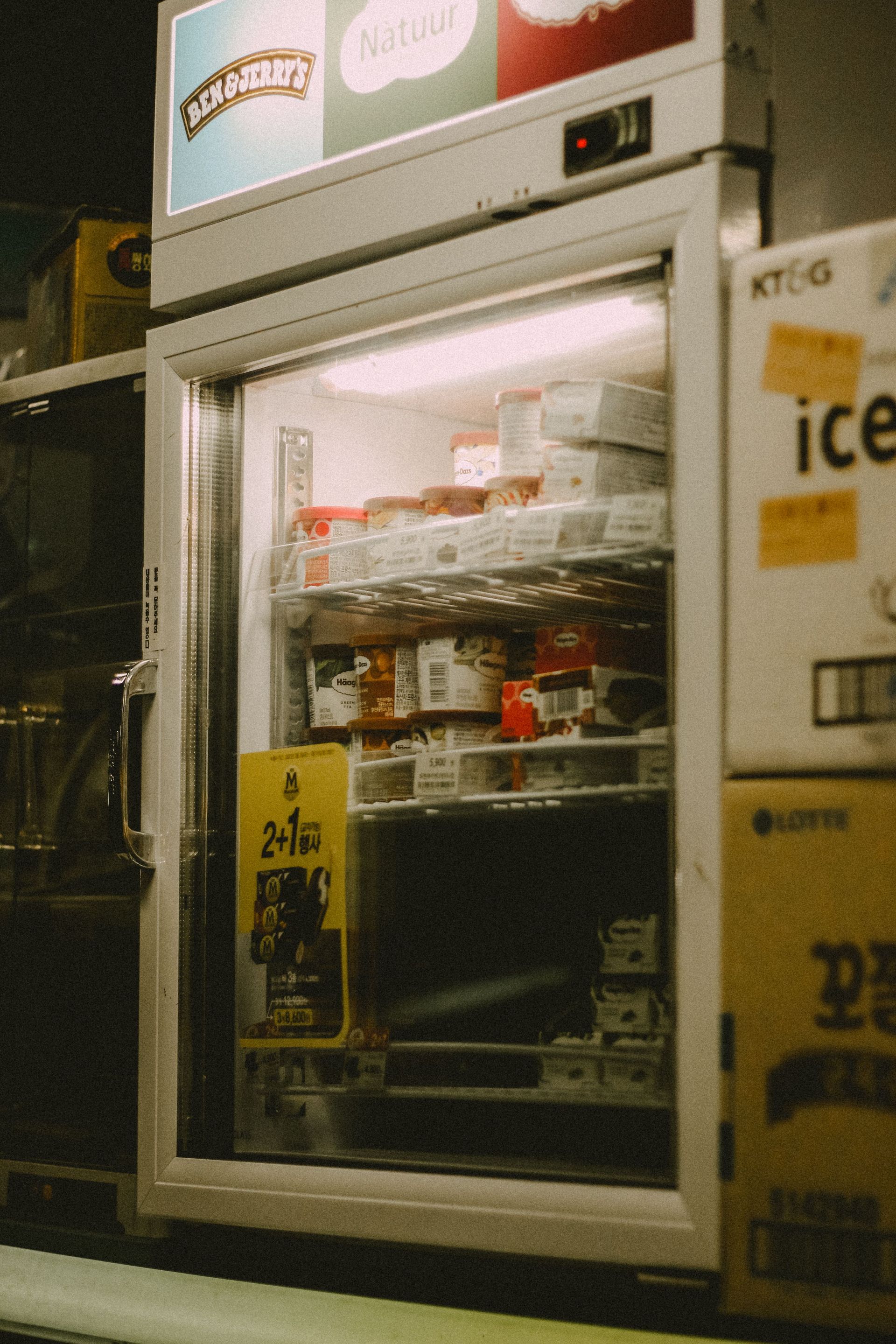 Open refrigerator stocked with drinks and snacks in a convenience store.