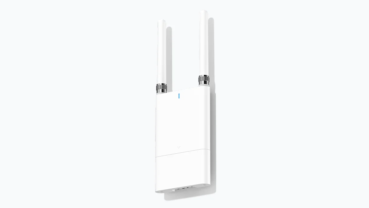 White security camera with a protective sun visor, outdoors.