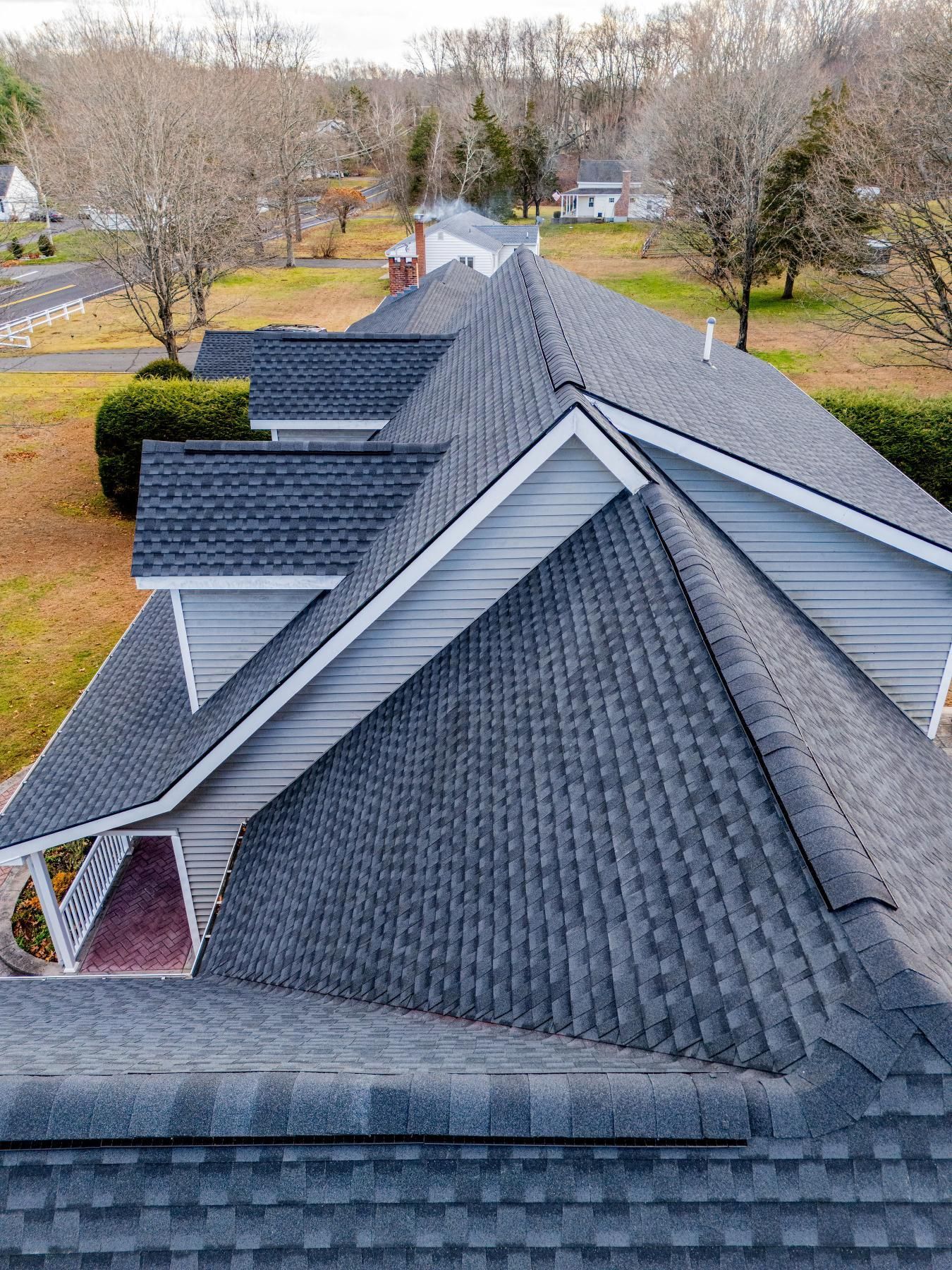 Gray asphalt shingle roof on a house with white trim, seen from above.