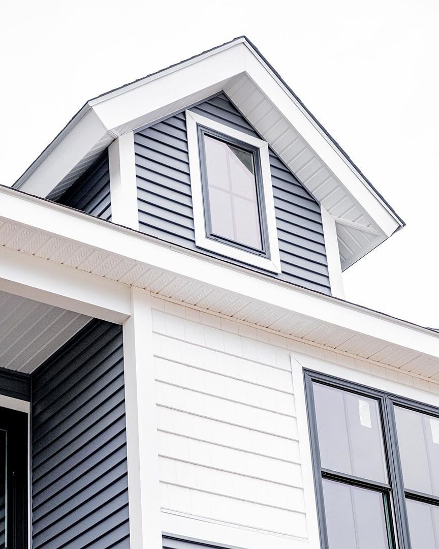 Blue and white house exterior with a dormer, window, and roof.