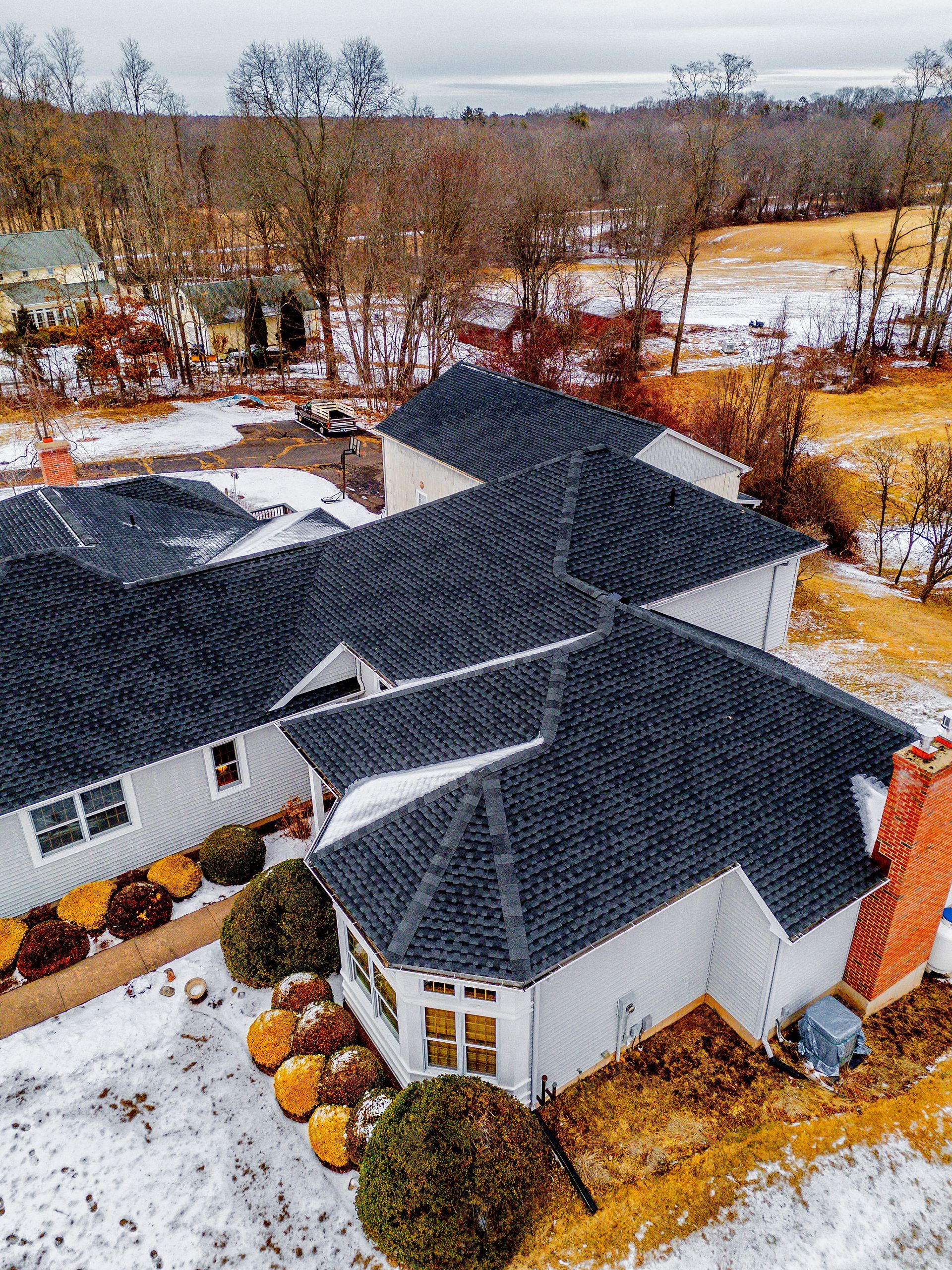 White house with dark roof in a snowy landscape.