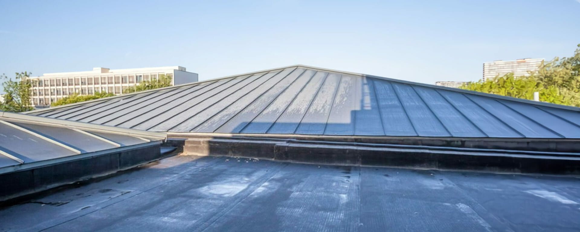 A close up of a roof with a building in the background.