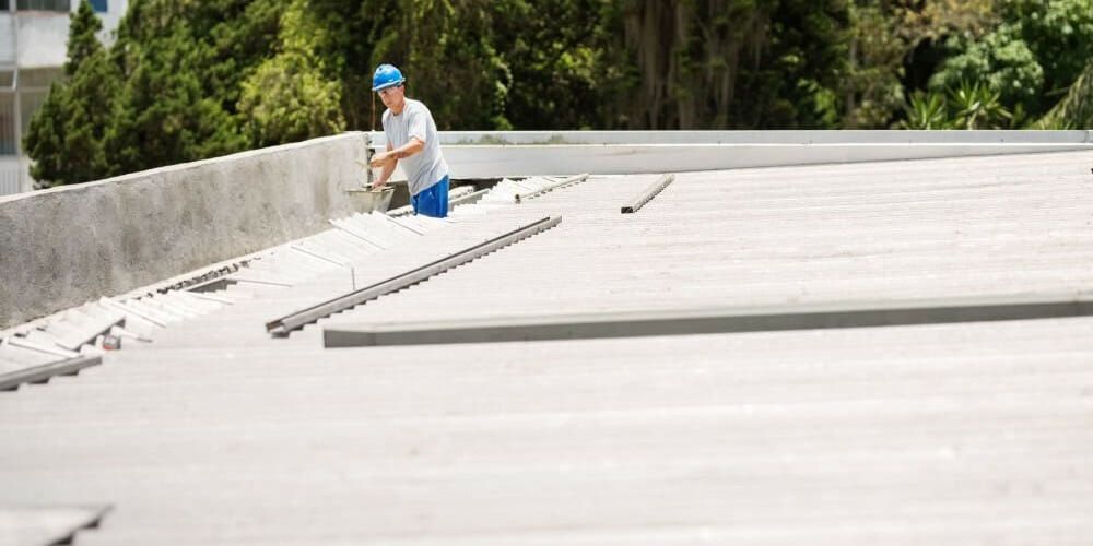 A man is working on the roof of a building.