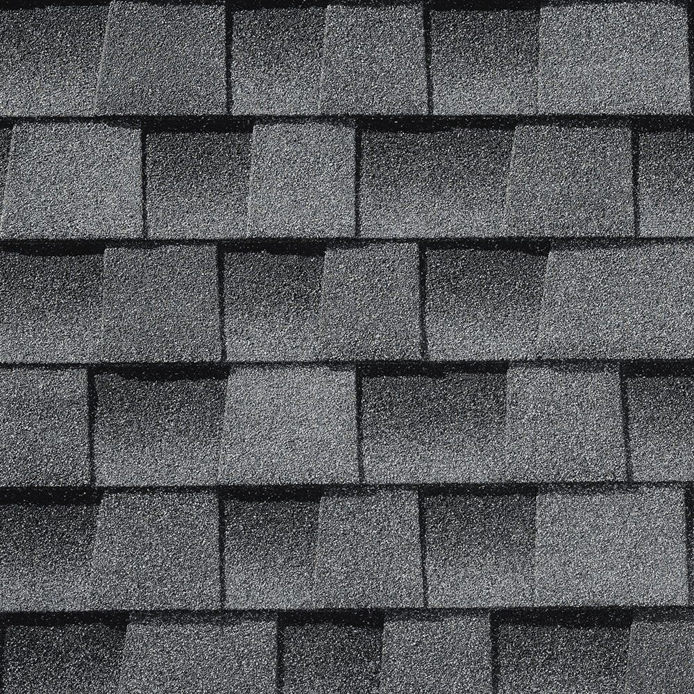 Dark gray asphalt shingles on a roof, creating a textured pattern.