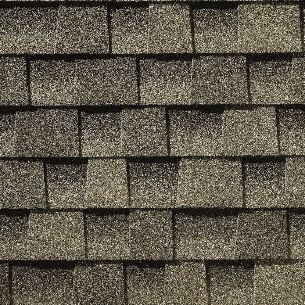 Close-up of overlapping asphalt roof shingles in shades of gray.