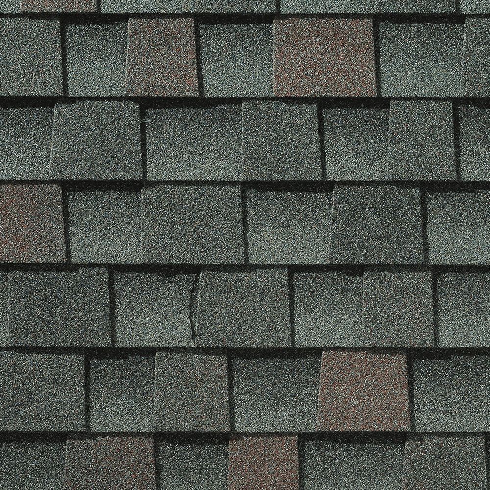 Close-up of asphalt roof shingles in a mix of gray and brown tones.