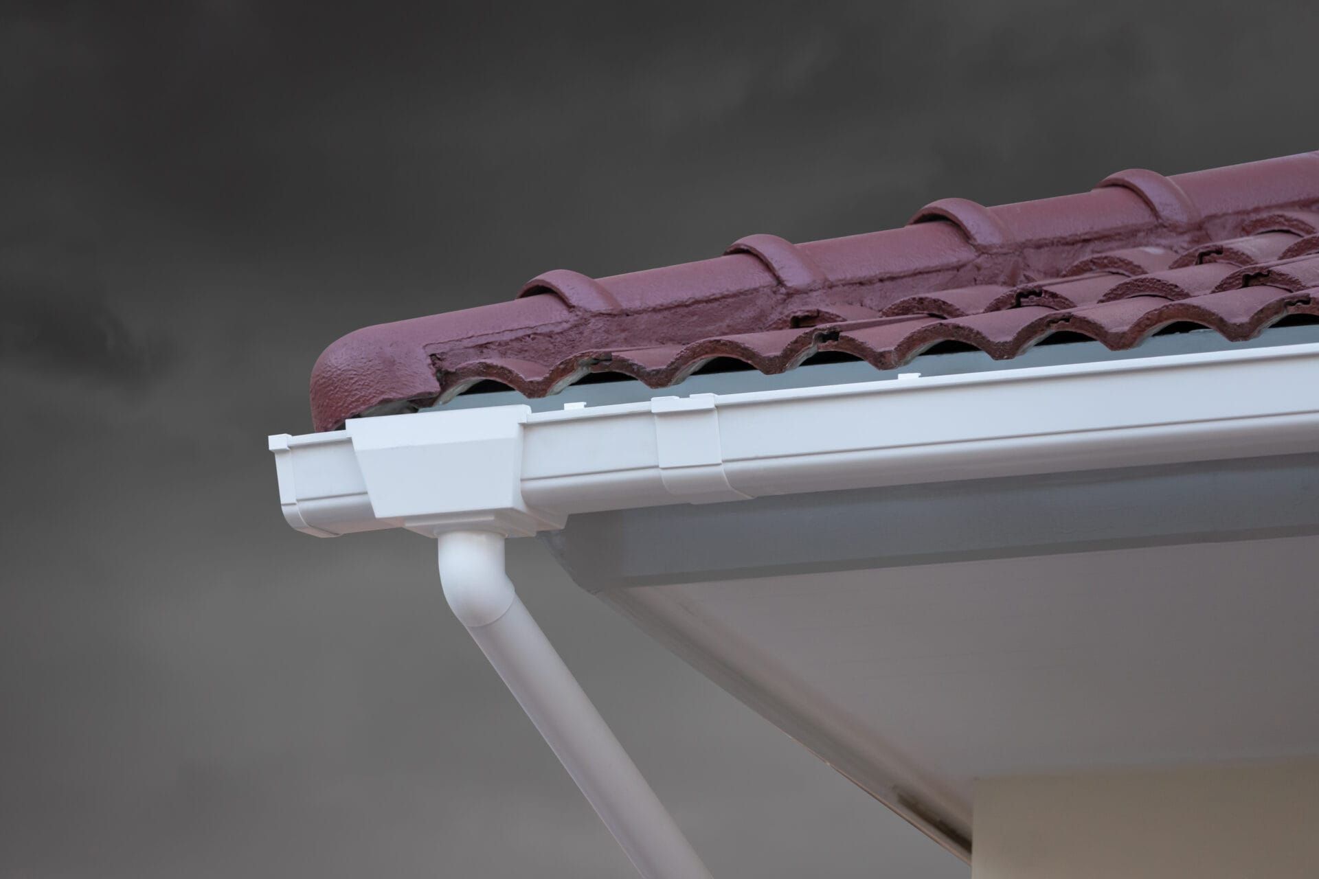A close up of a gutter on a roof of a house.