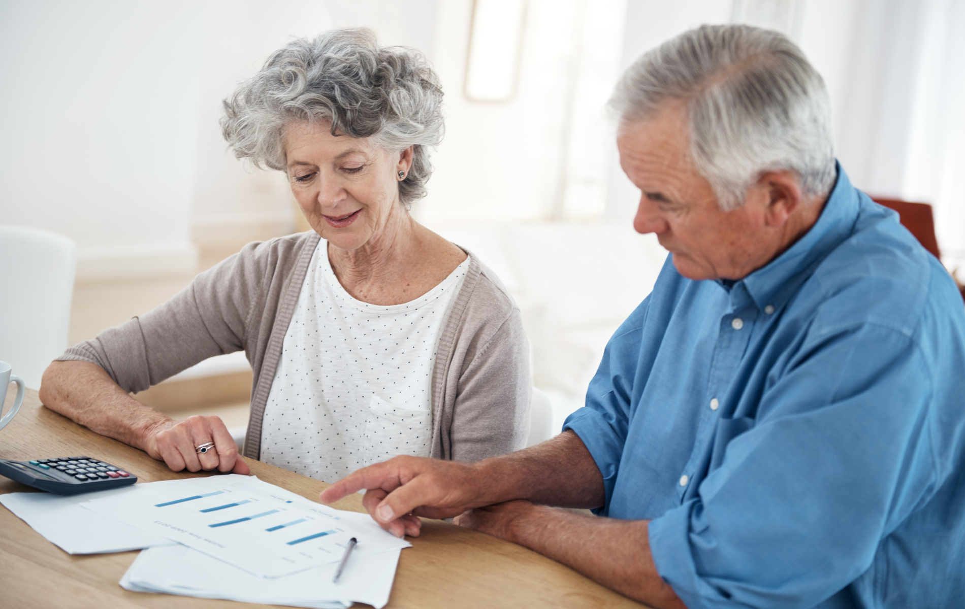 Two people reviewing documents at a table in a bright room