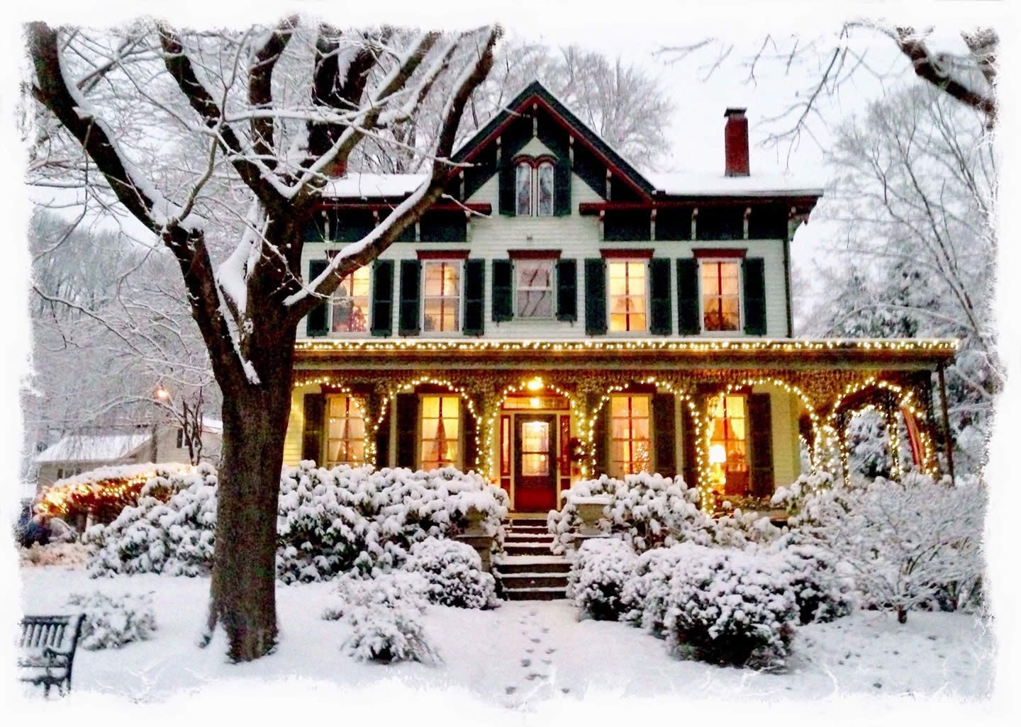 A house is covered in snow and christmas lights