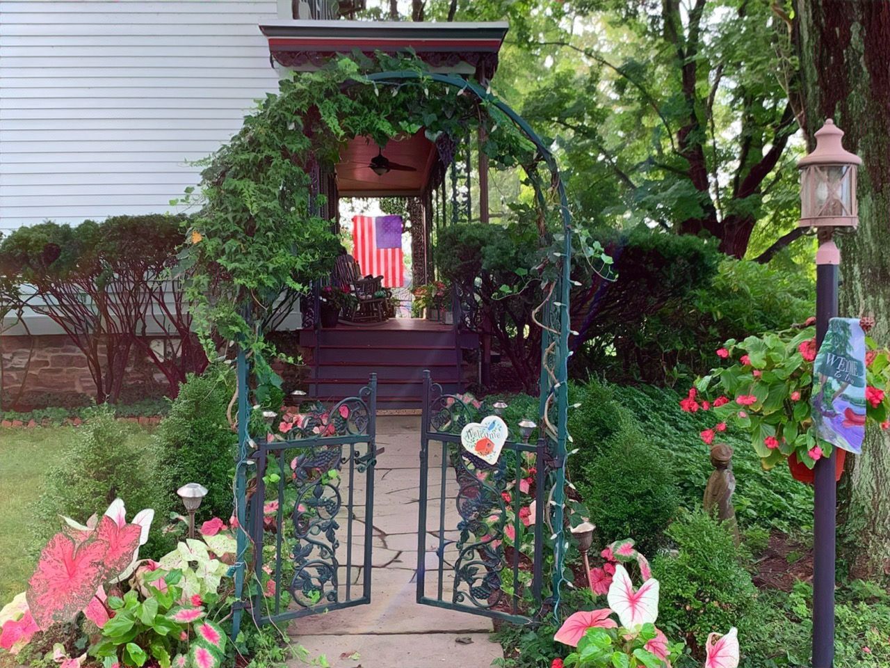 A garden with a gate and flowers in front of a house