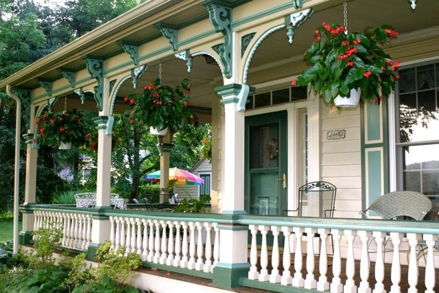A porch with hanging baskets of flowers on it
