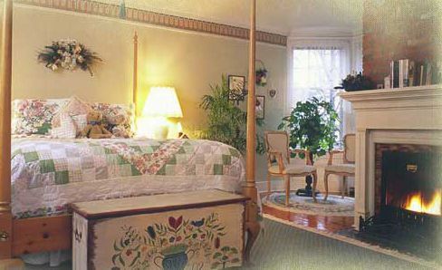 A bedroom with a four poster bed and a fireplace