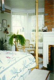A bedroom with a four poster bed and a fireplace