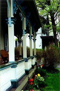 A porch with columns and flowers in front of a house.