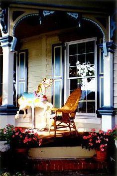 A porch with a carousel horse and a rocking chair