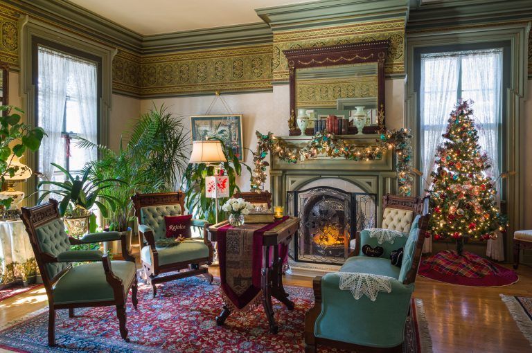 A living room decorated for christmas with a fireplace and a christmas tree.