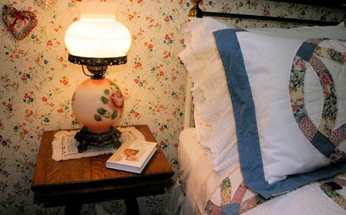 A lamp sits on a small table next to a bed