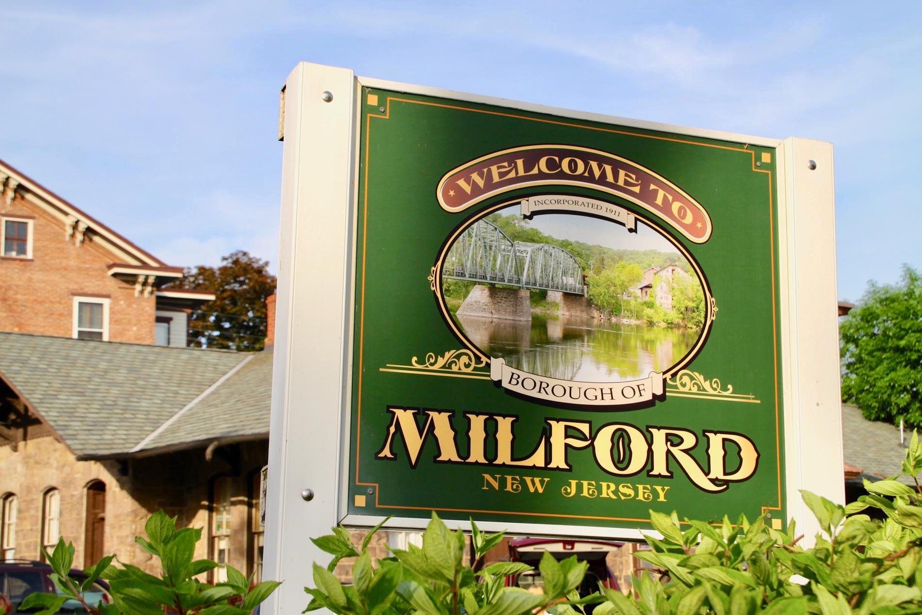A green sign that says welcome to milford new jersey
