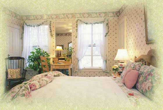 A bedroom with a bed , chair , desk and two windows