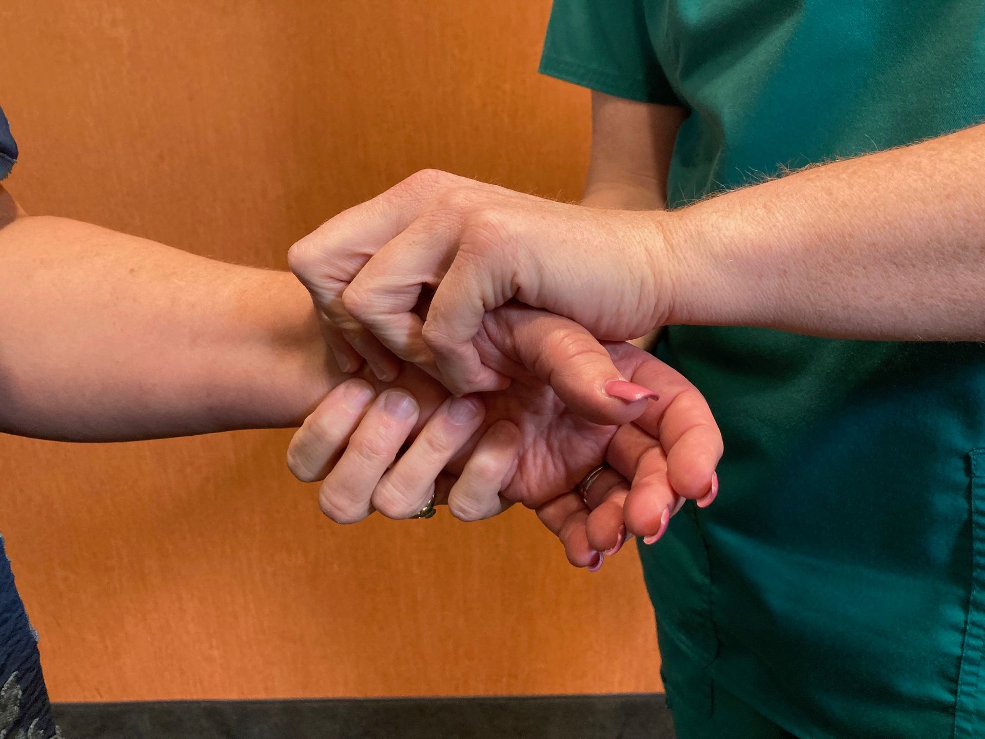 A person is holding another person 's wrist with their hands.