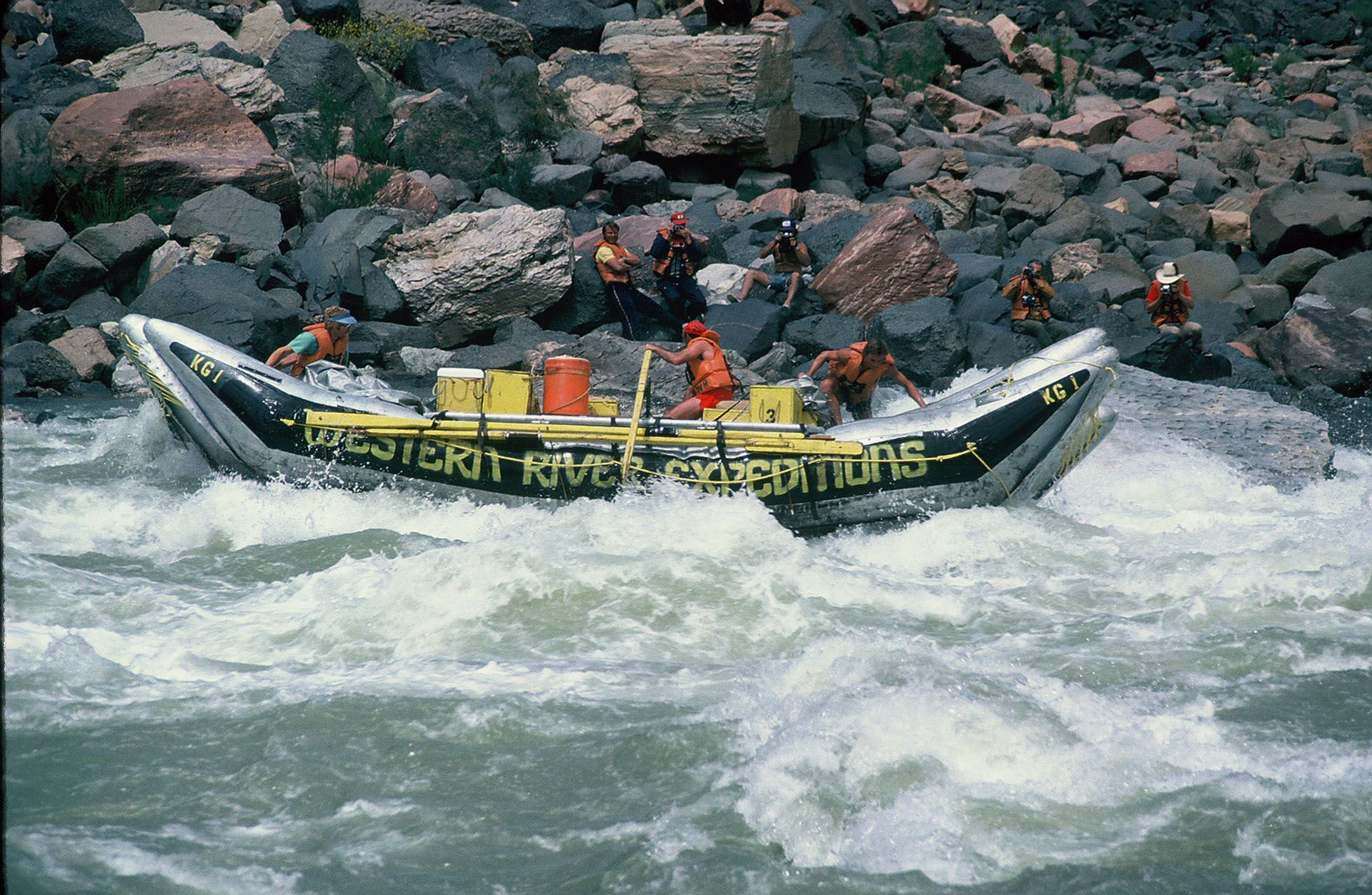 A rower guides a small Western River Expeditions raft through a rocky rapid