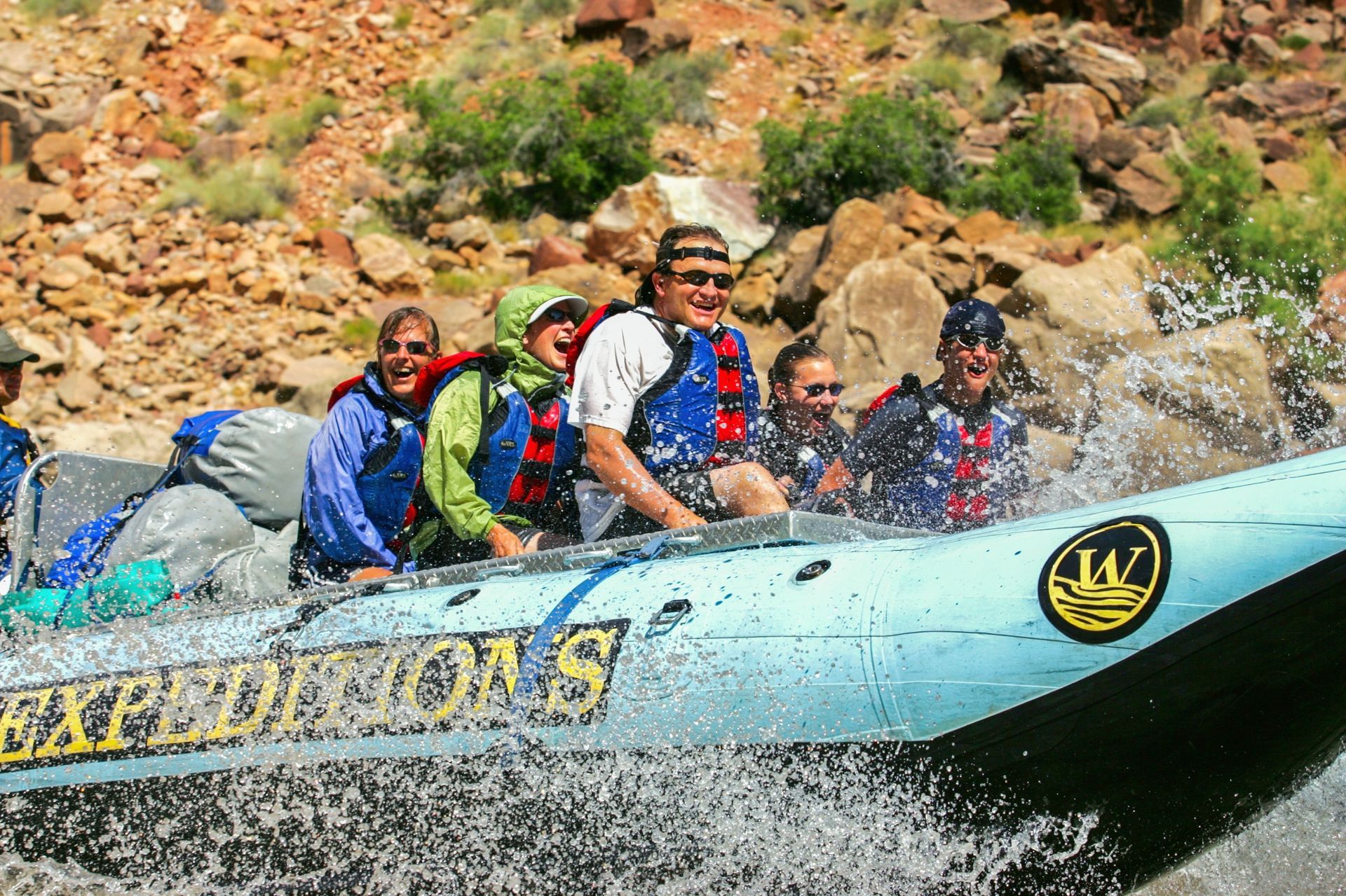 Guests ride the front of a Snout-Rig raft in Cataract Canyon
