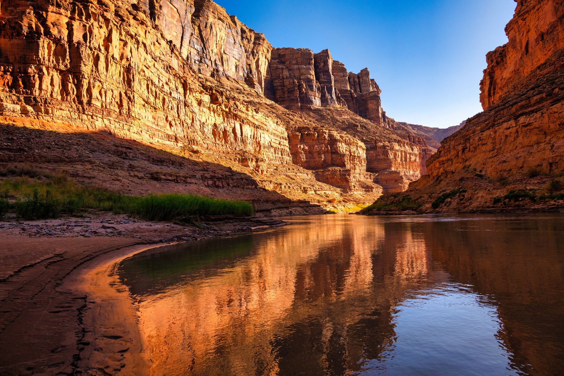 Cataract Canyon’s cliffs reflected in calm river water