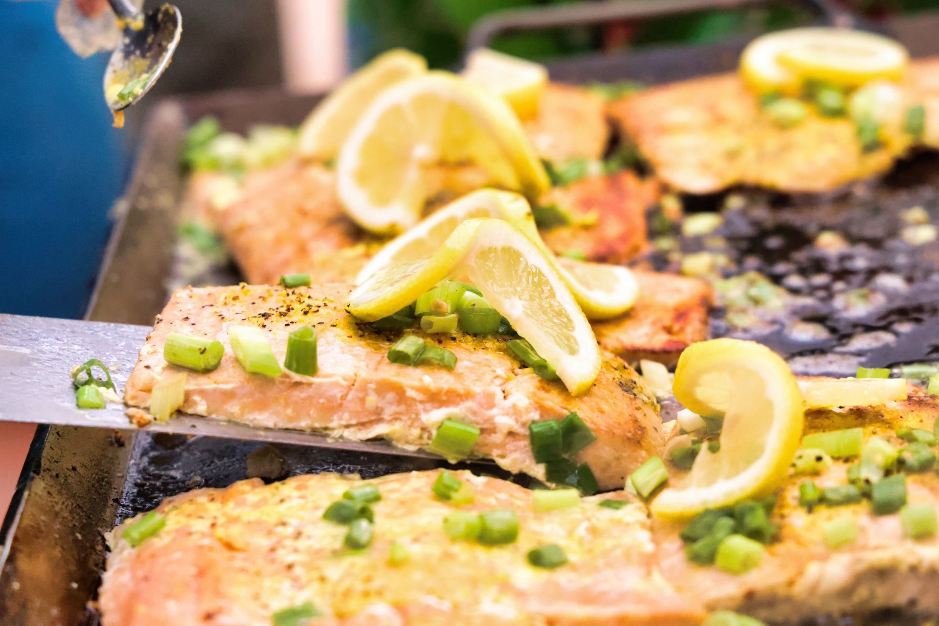 Fish fillets with lemon and herbs cooking on a grill
