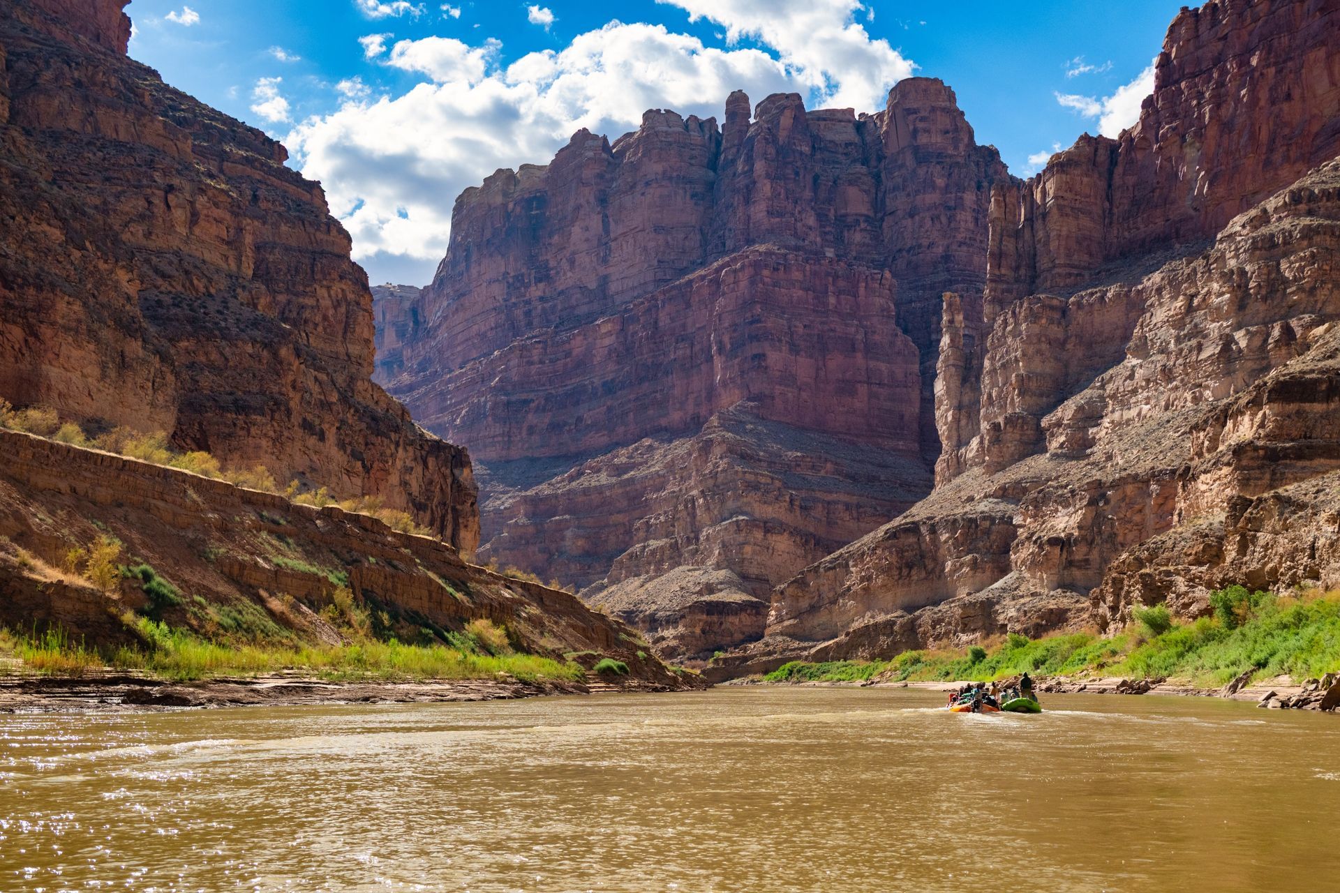 Small rafts float below the towering cliffs of Cataract Canyon