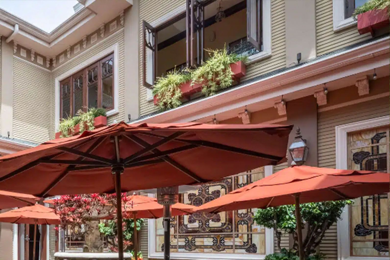 Hotel entrance with balconies and red patio umbrellas