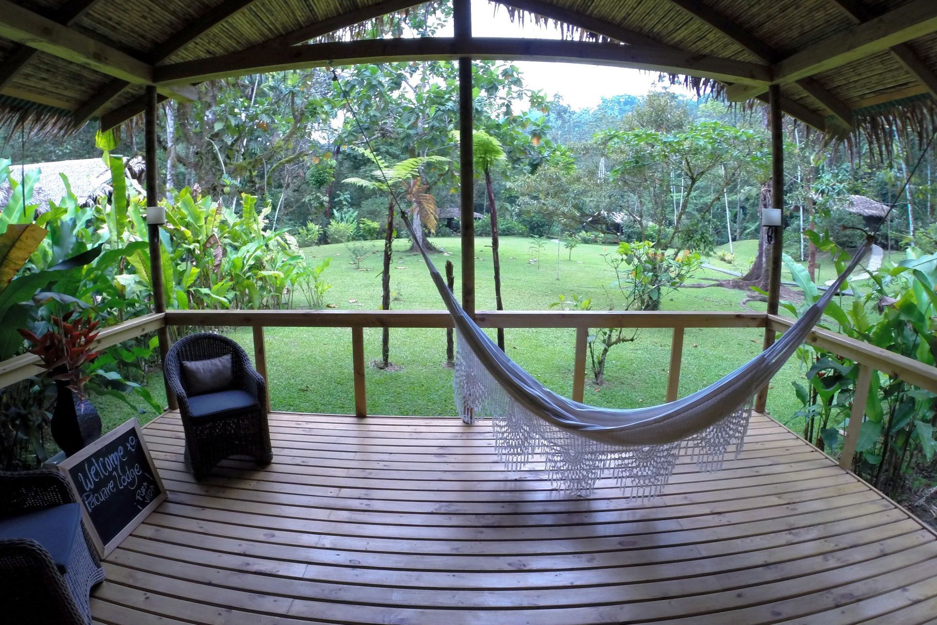 Hammock on a covered deck overlooking tropical gardens