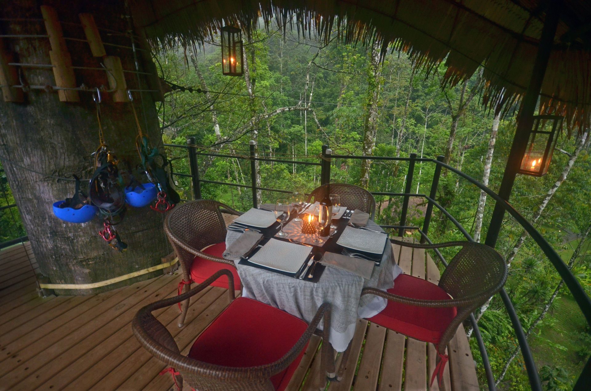 Candlelit dining table on a forest canopy deck