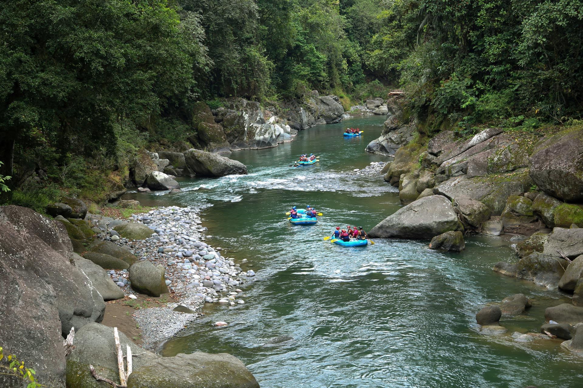 Rafts travel through a narrow, rocky river gorge