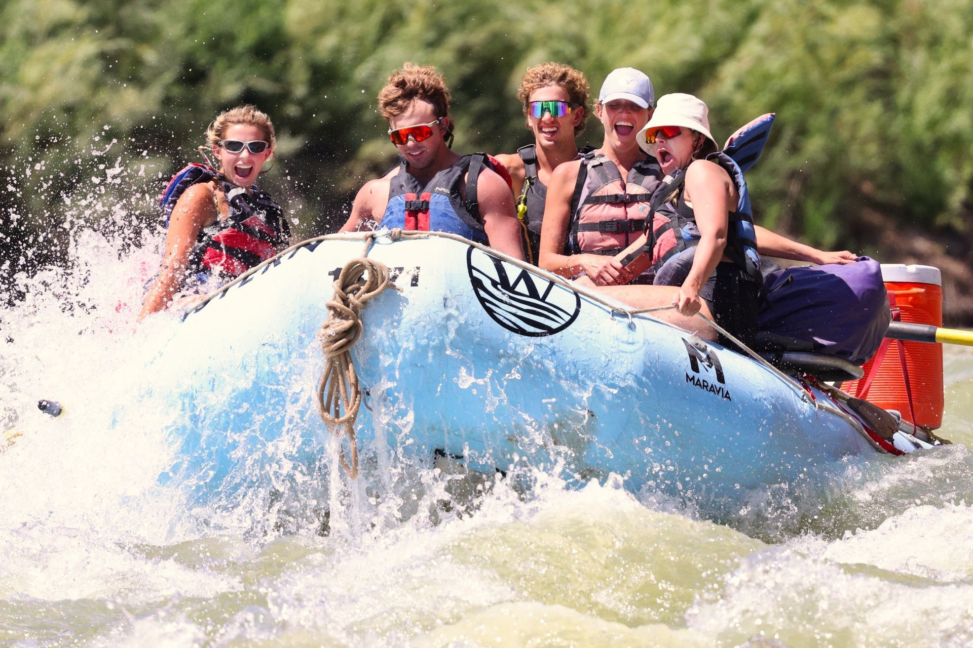 Rafters hold on as a blue oar boat passes through a Desolation Canyon rapid