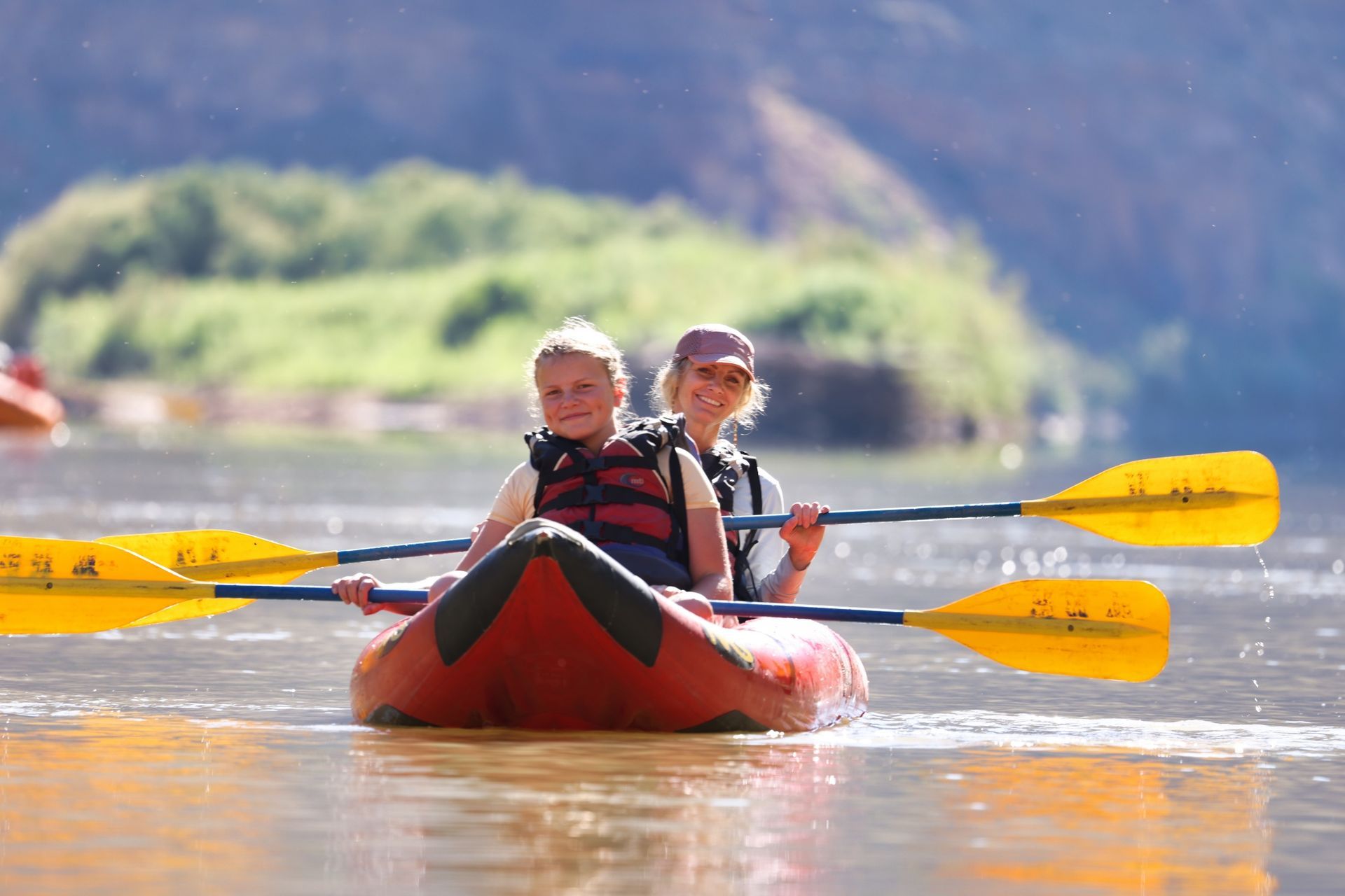 Mother and daughter in an inflatable kayak on a calm section of the Green River through Desolation Canyon 