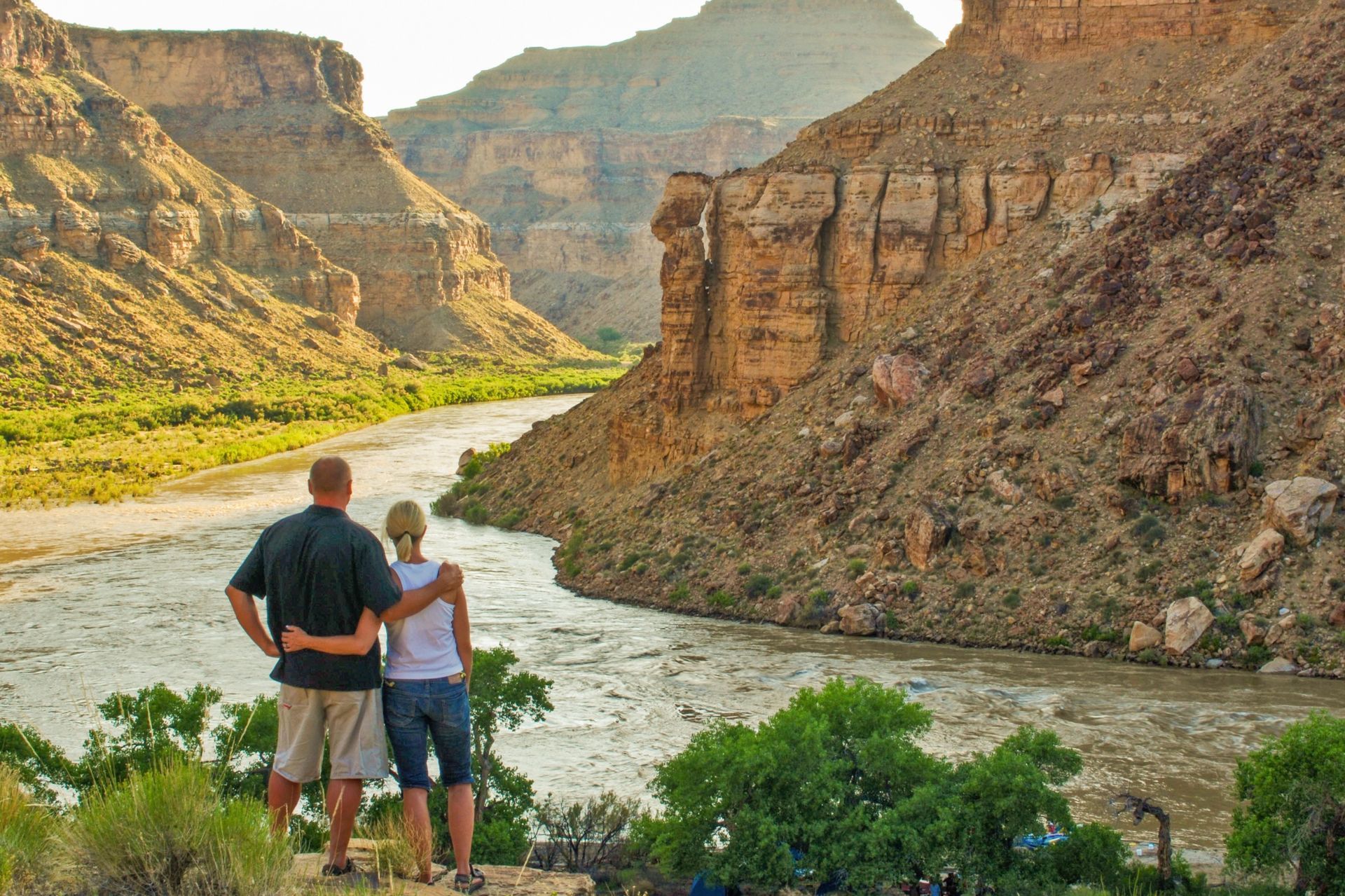 Two hikers look down over the river in Desolation Canyon