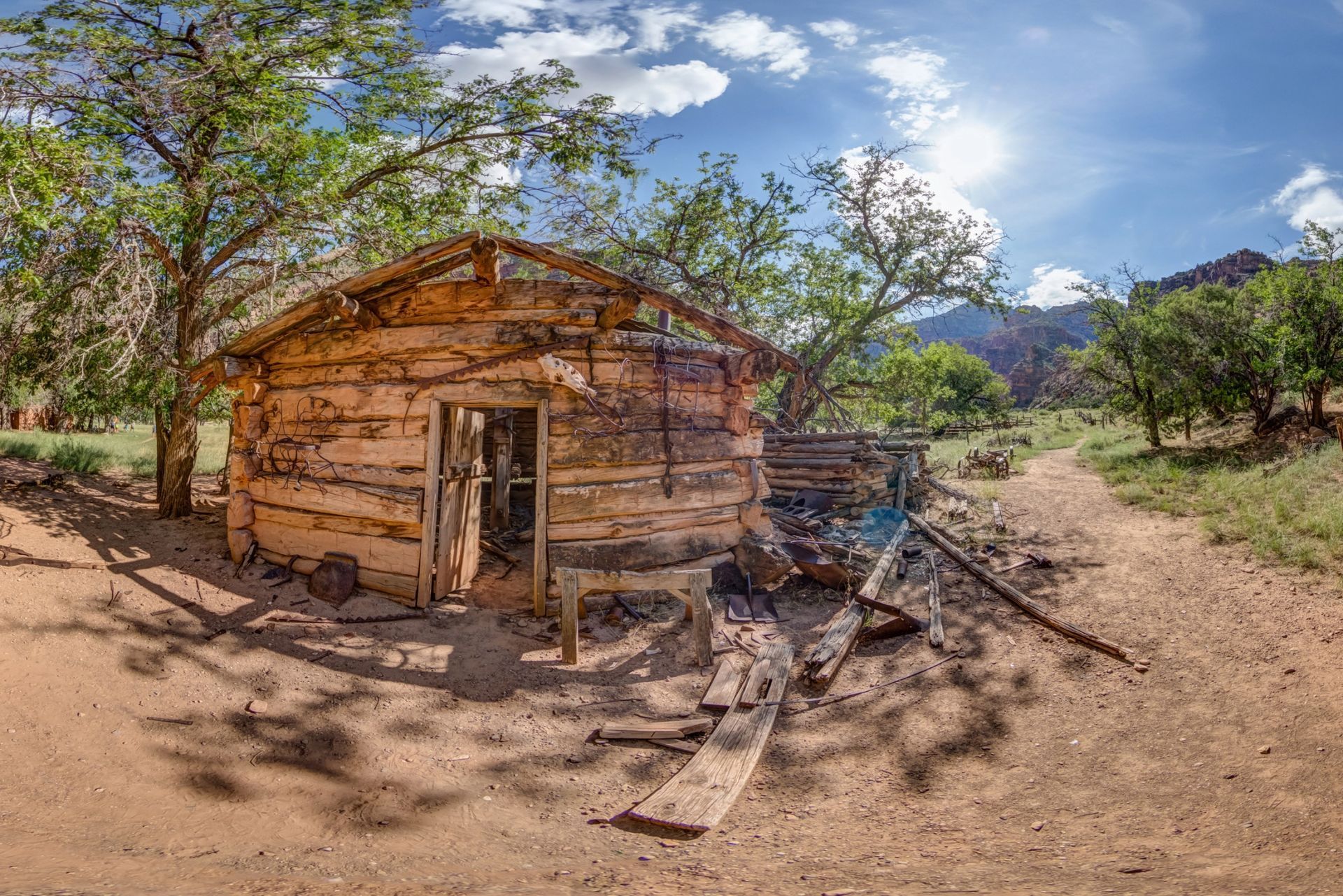 View of an old homesteader's cabin with artifacts outside.