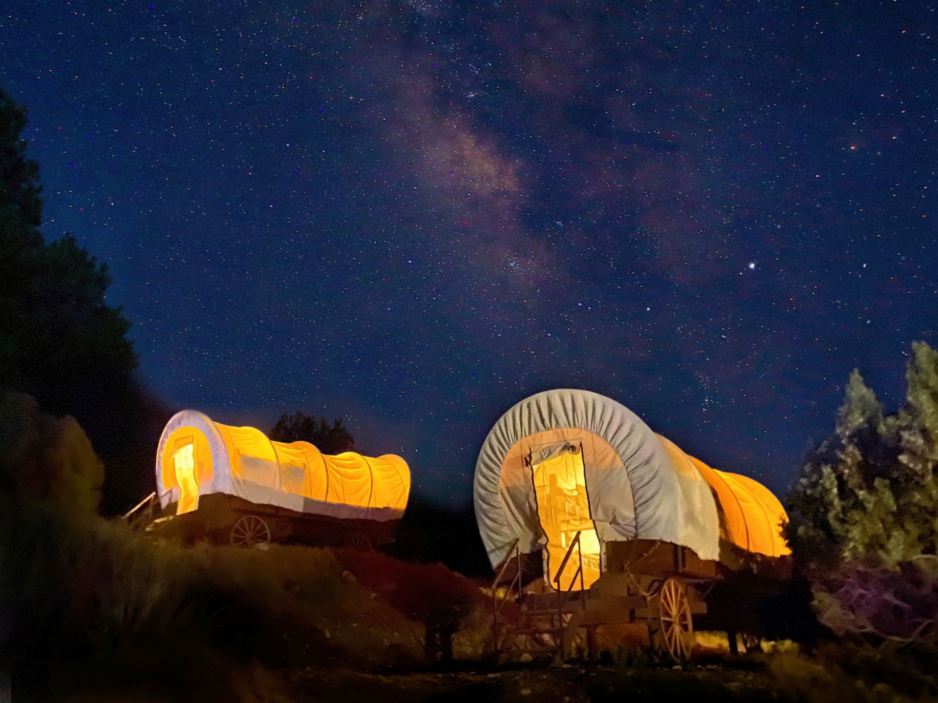 Illuminated covered wagons beneath the night sky at Bar 10 Ranch