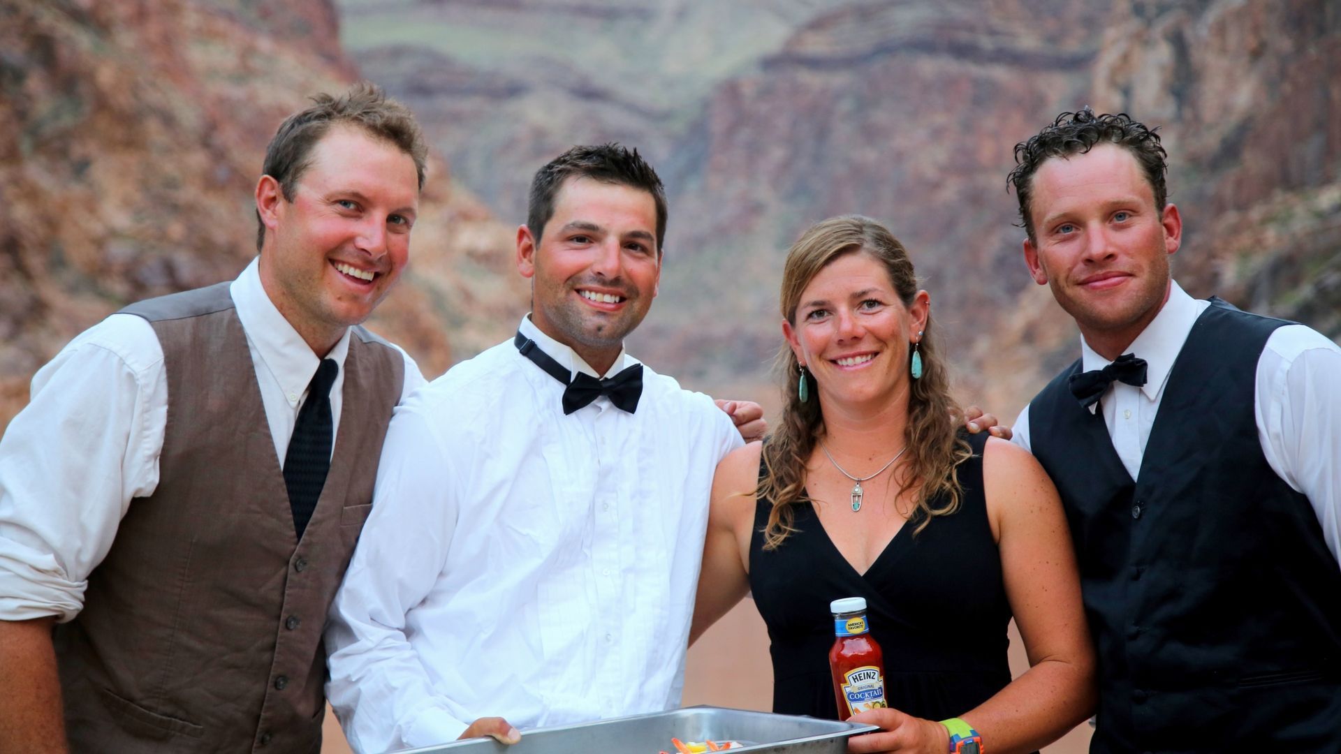 Four guides serving drinks beside the river
