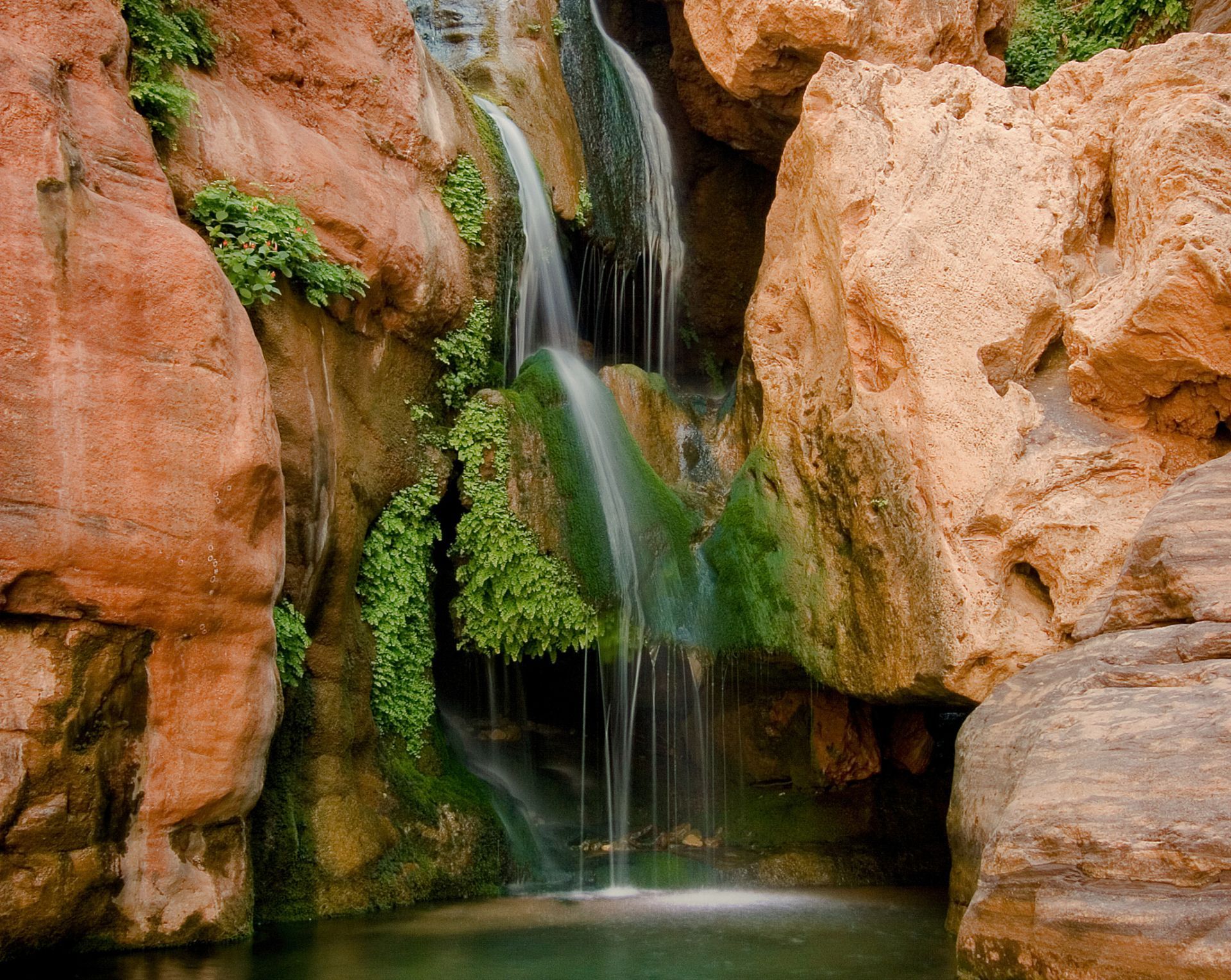Water cascades through Elves Chasm into an emerald pool