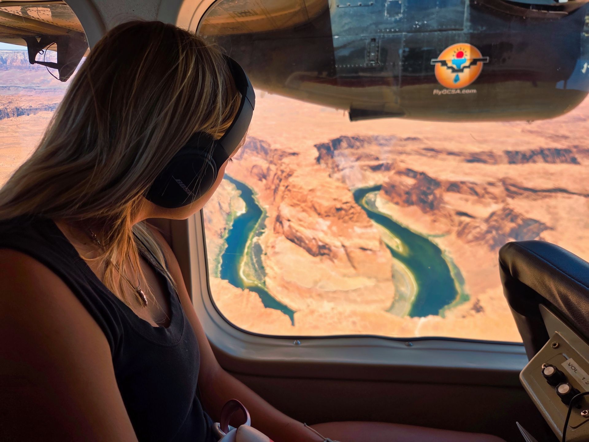 Passenger looks through an airplane window at Horseshoe Bend