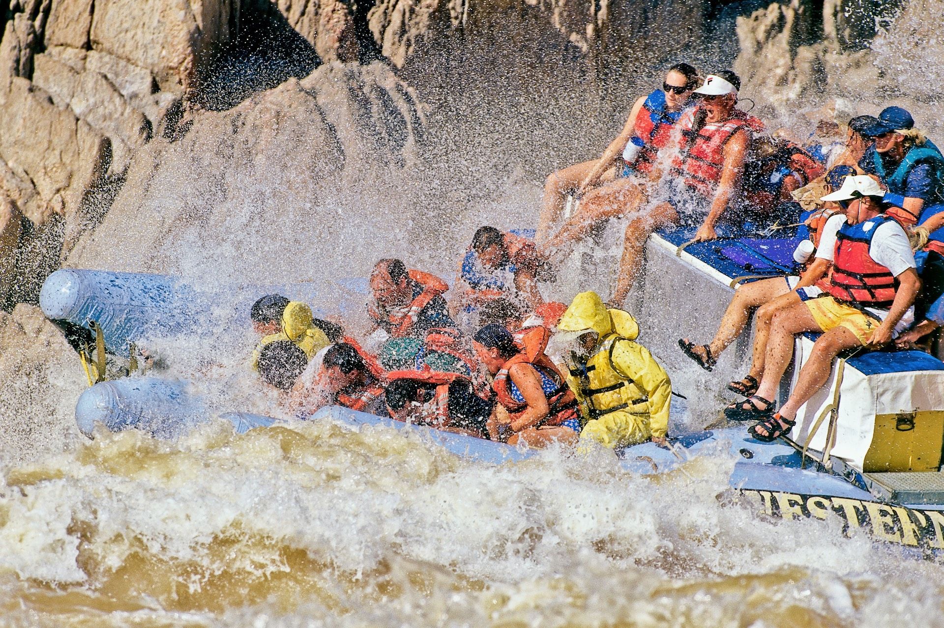 Guests on the front of a J-Rig ride through a large whitewater wave