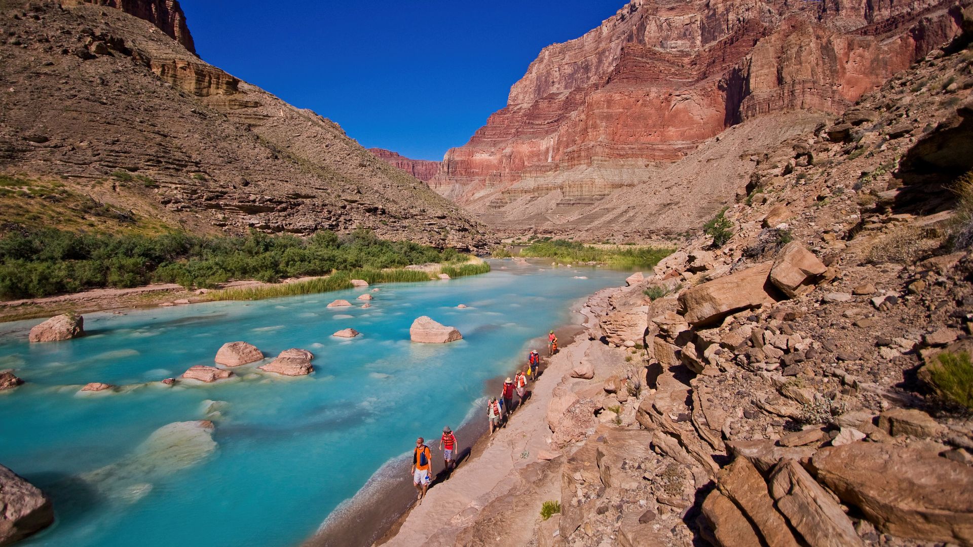 Rafters walking beside the turquoise Little Colorado River in Grand Canyon