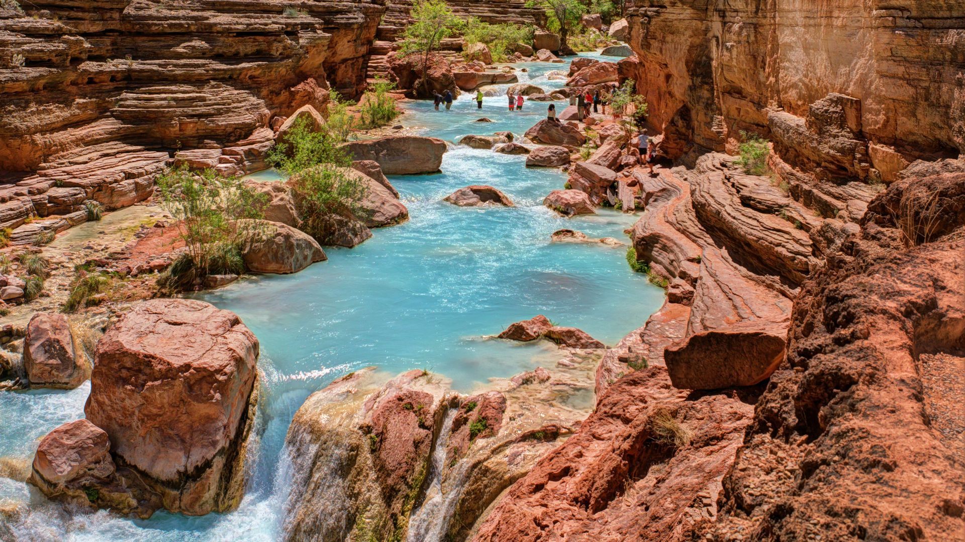 Turquoise pools and small waterfalls between Havasu Creek’s red rock walls