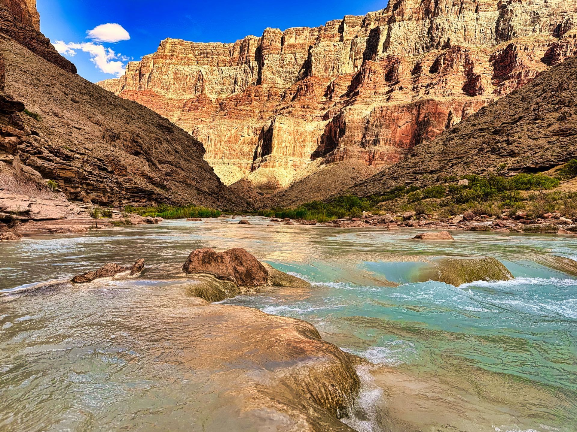 The turquoise Little Colorado River flowing over rock ledges