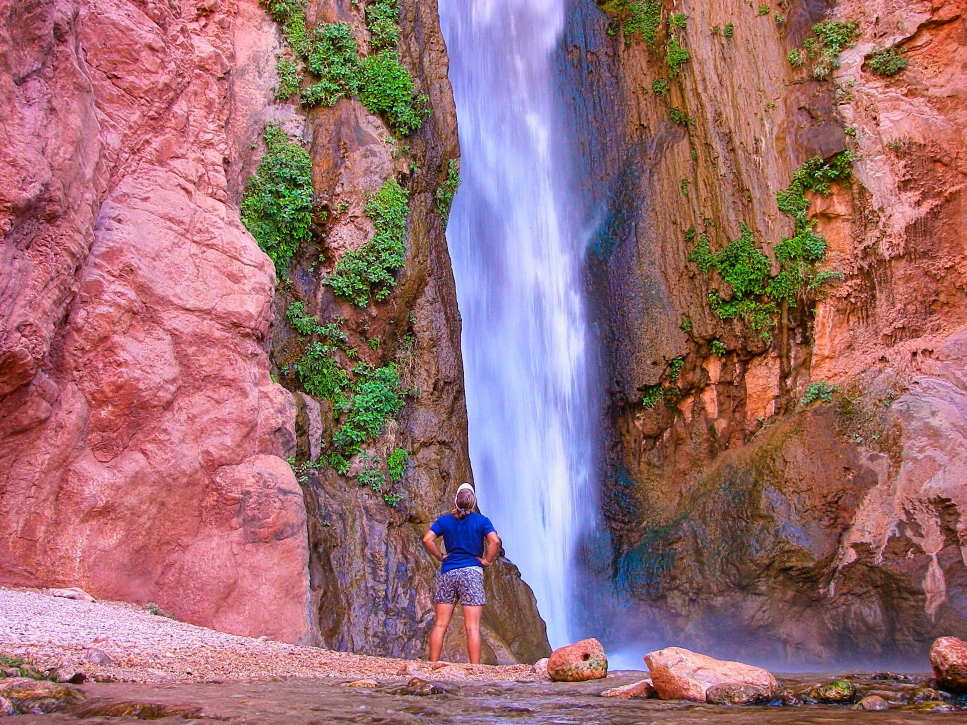 A visitor looks up at Deer Creek Falls