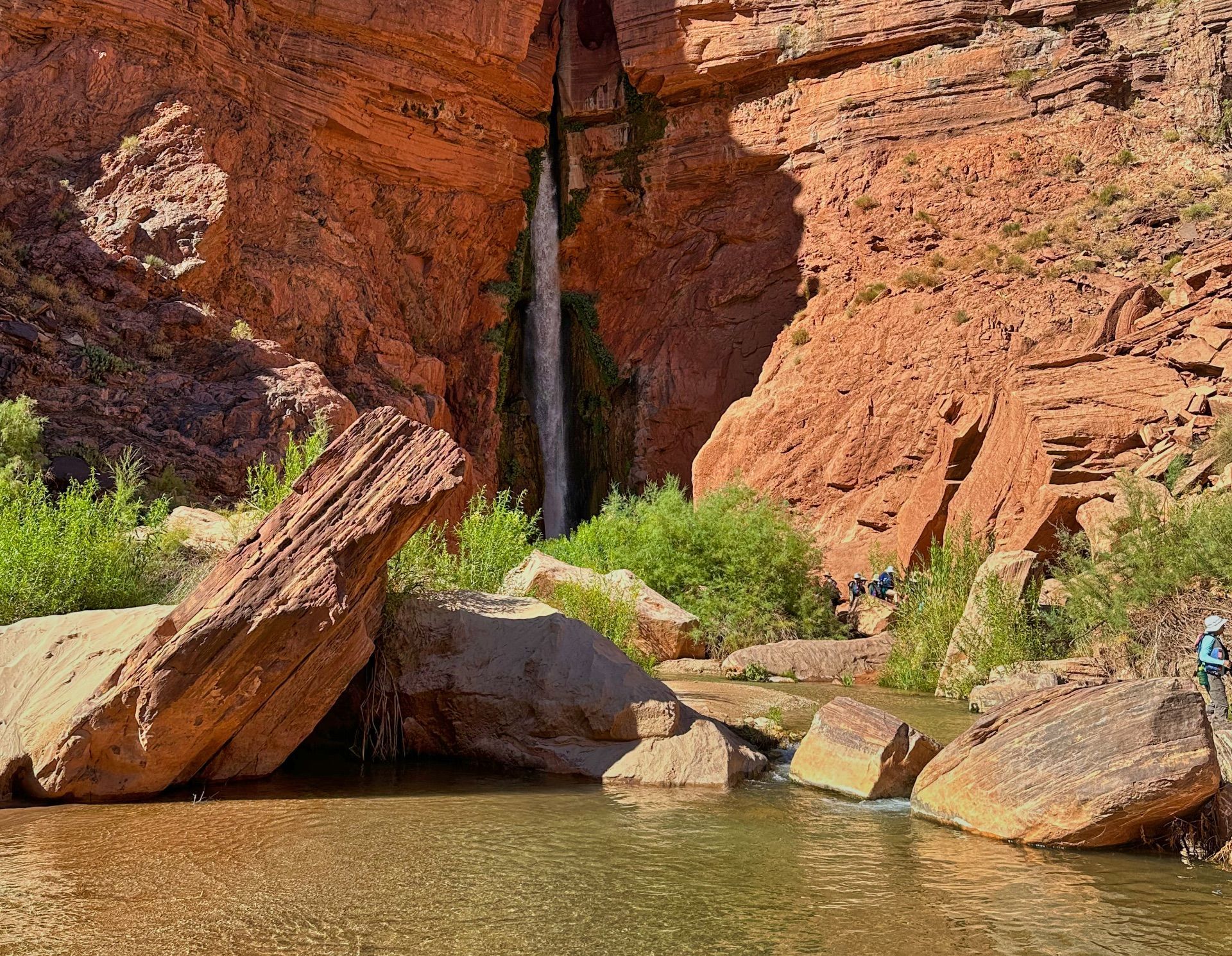 Deer Creek Falls cascading between red sandstone cliffs