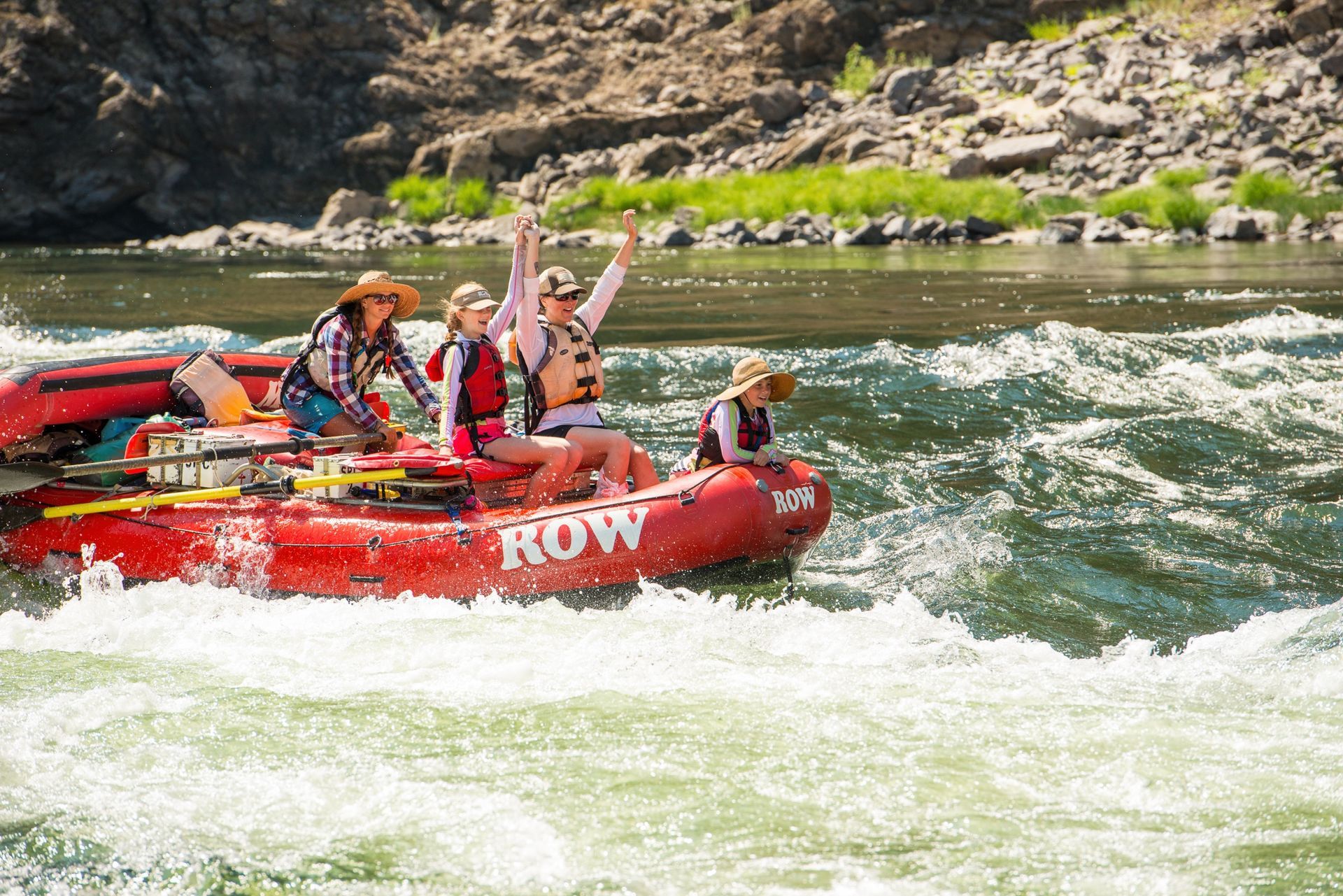 Guests riding an oar raft through whitewater on the Lower Salmon River